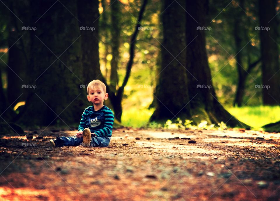 Boy sitting on ground in park