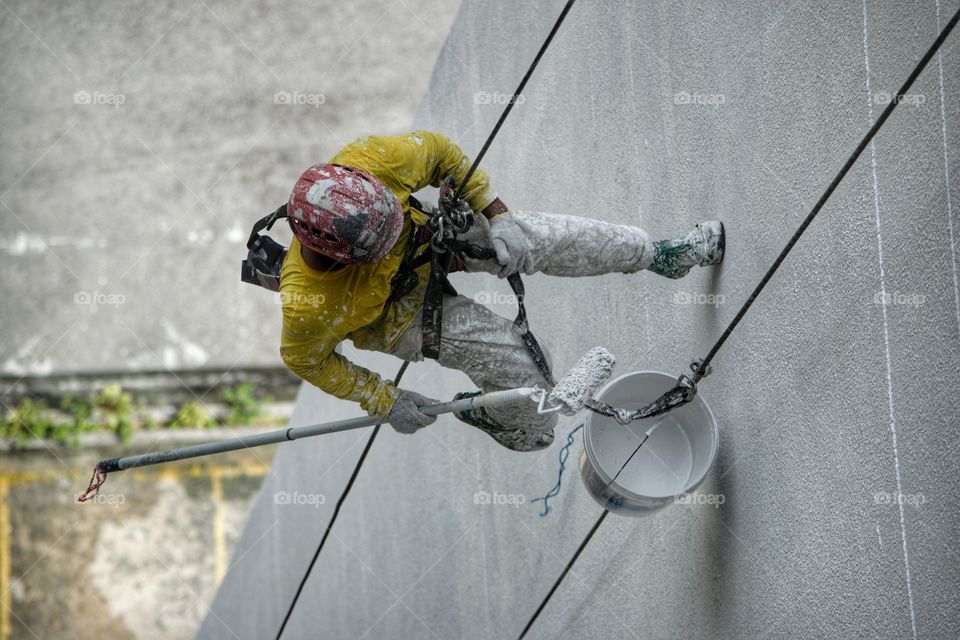 Worker abseiling down side of tower block in Kuala Lumpur Malaysia