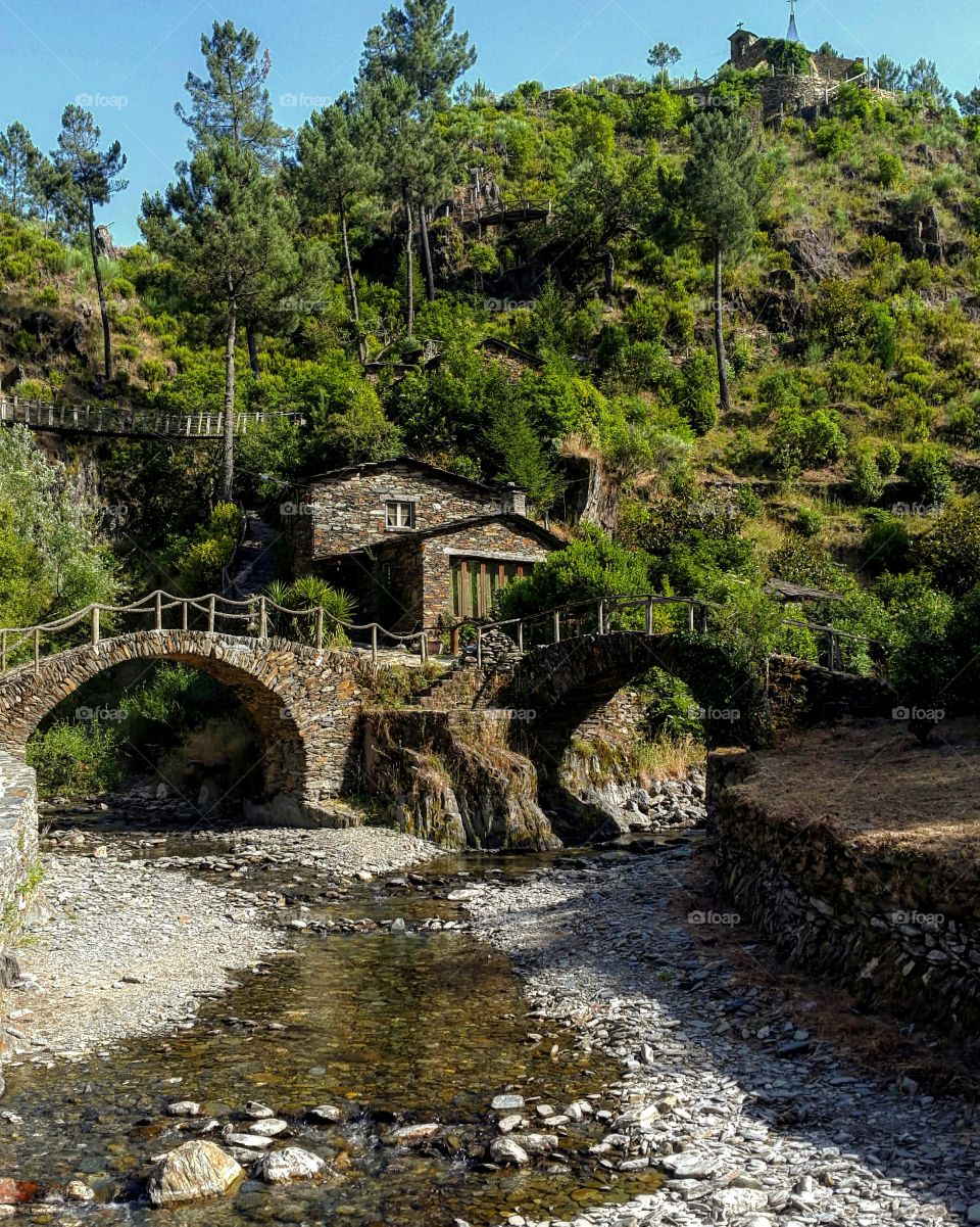 Stone bridge over stream near mountain