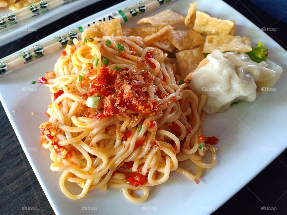 Spicy Hot Noodle from Indonesia. complete yummiest with chickem dimsum and crispy topping.