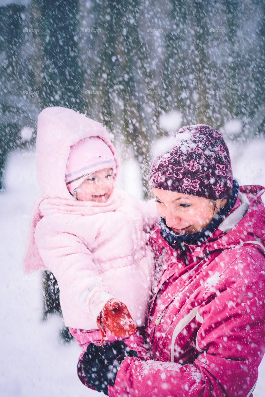 Mother spending time with her little daughter outdoors in the wintertime