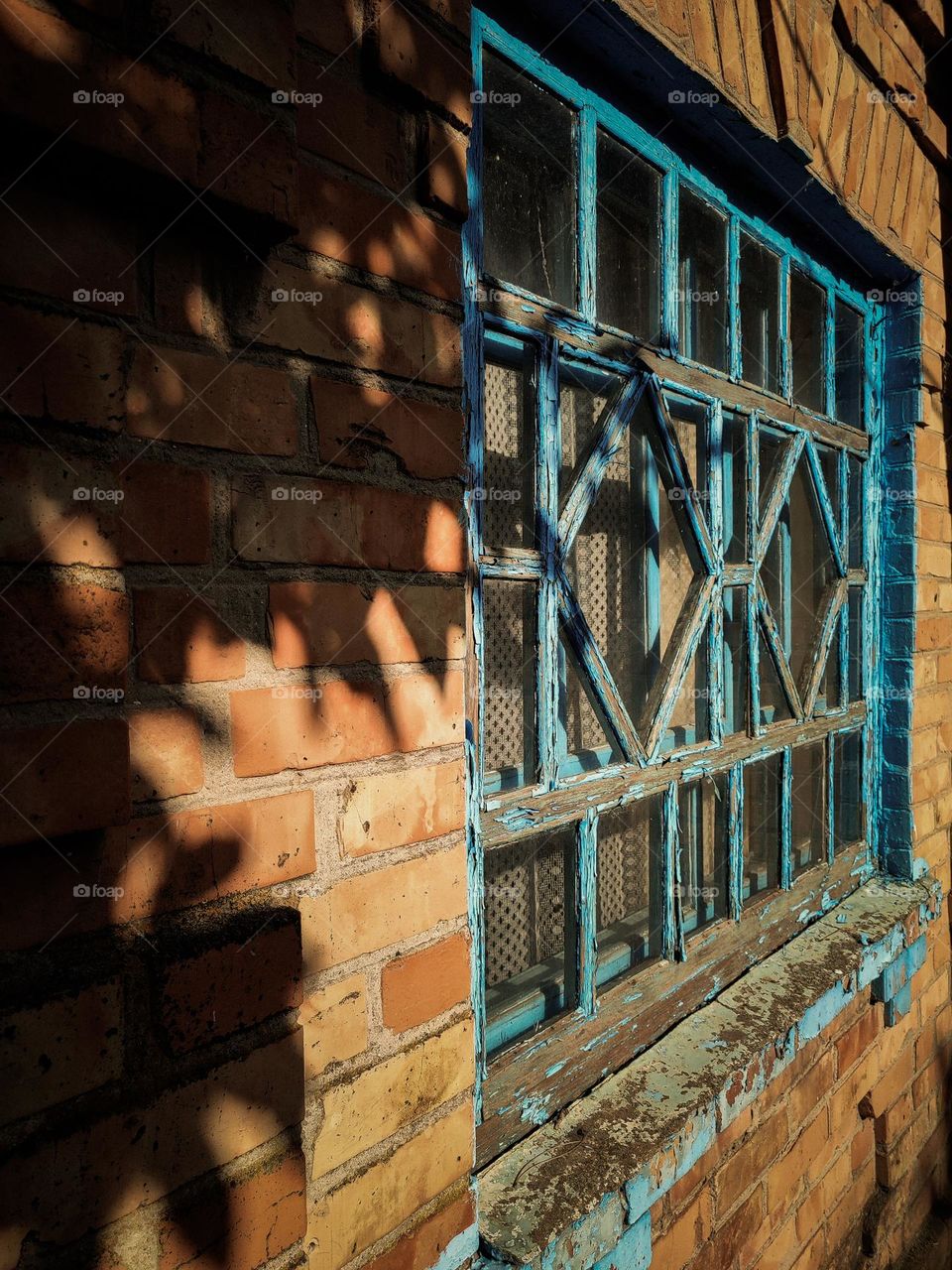 Old blue frame window in Ukrainian village in the sunny day. Leaves shadow. Vintage aesthetic