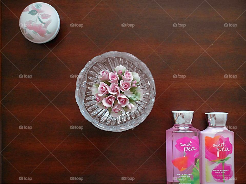 Pink items arranged on a wood table.