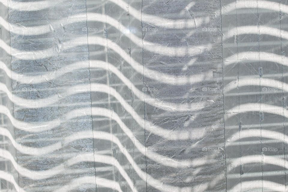 Side view of full curtain frame with squiggly lines.  Light-shadows,  white - gray