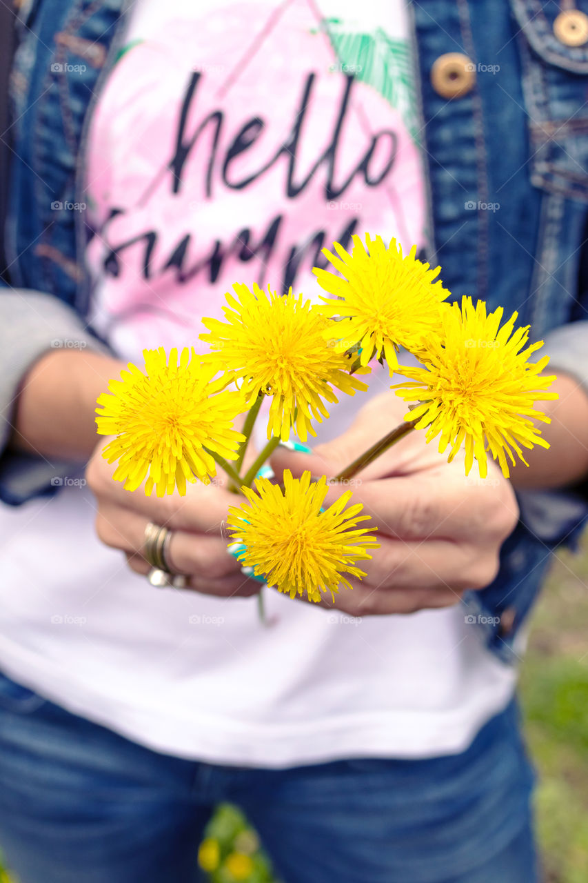 Girl holding a yellow dandelion
