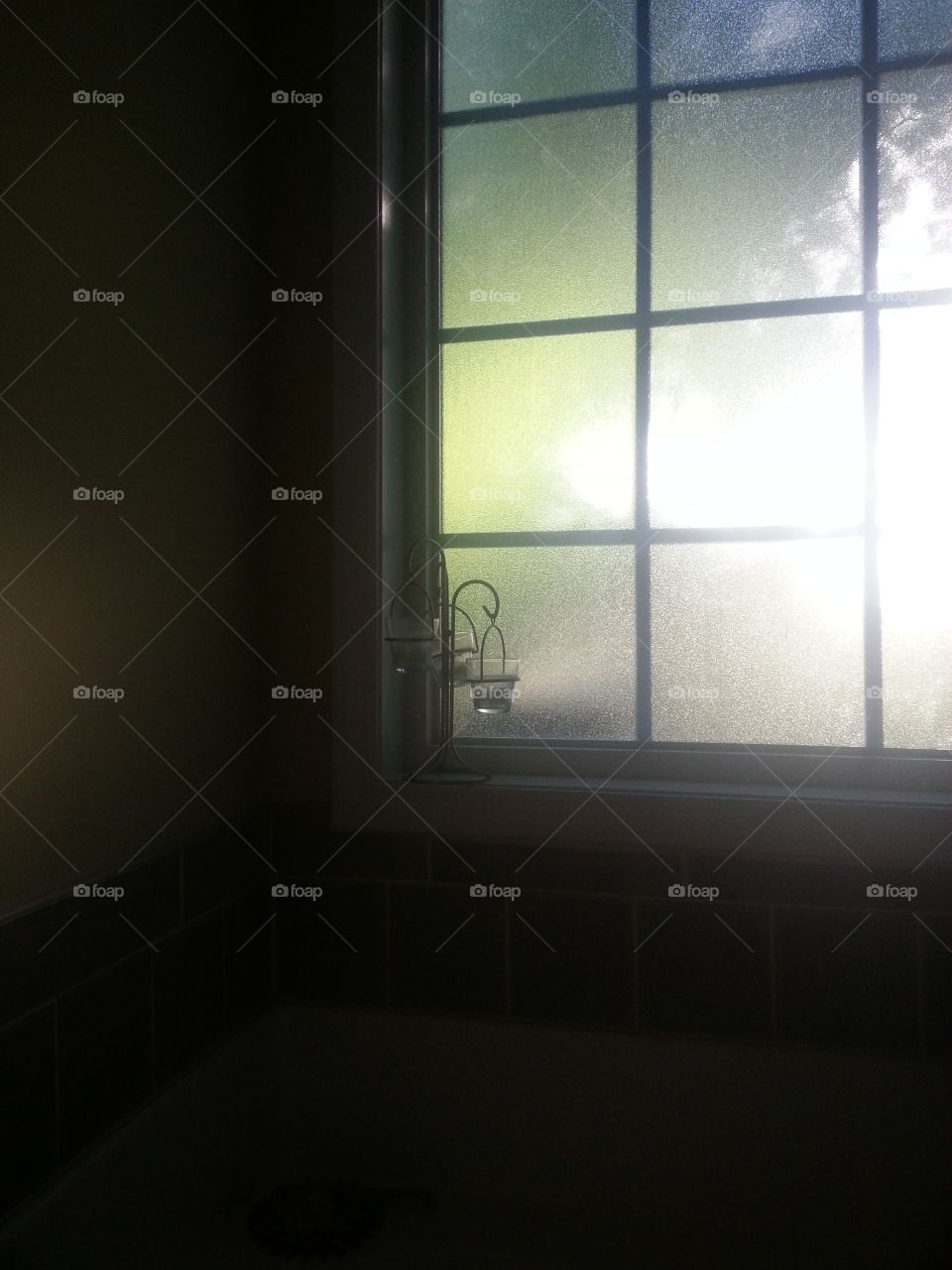 Relax time. window in the bathroom with sunlight coming through and candles