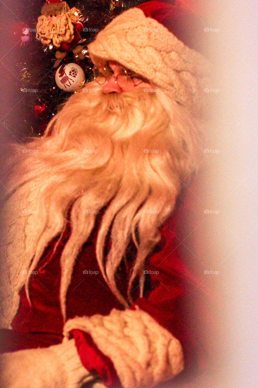 Real Santa Claus caught in his house through the window with the Christmas tree in the background. Happy holidays!