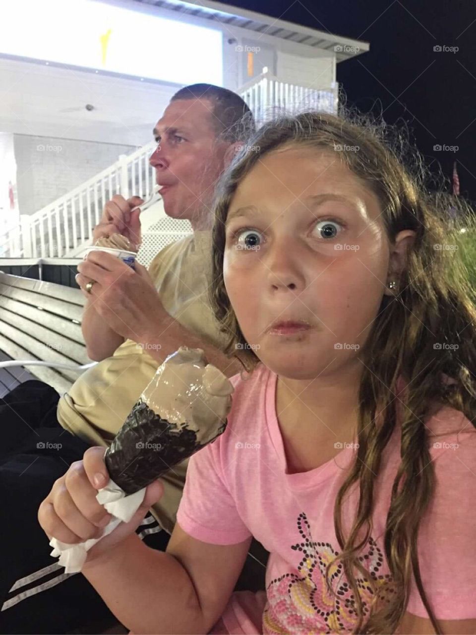 Girl making funny face while eating ice-cream