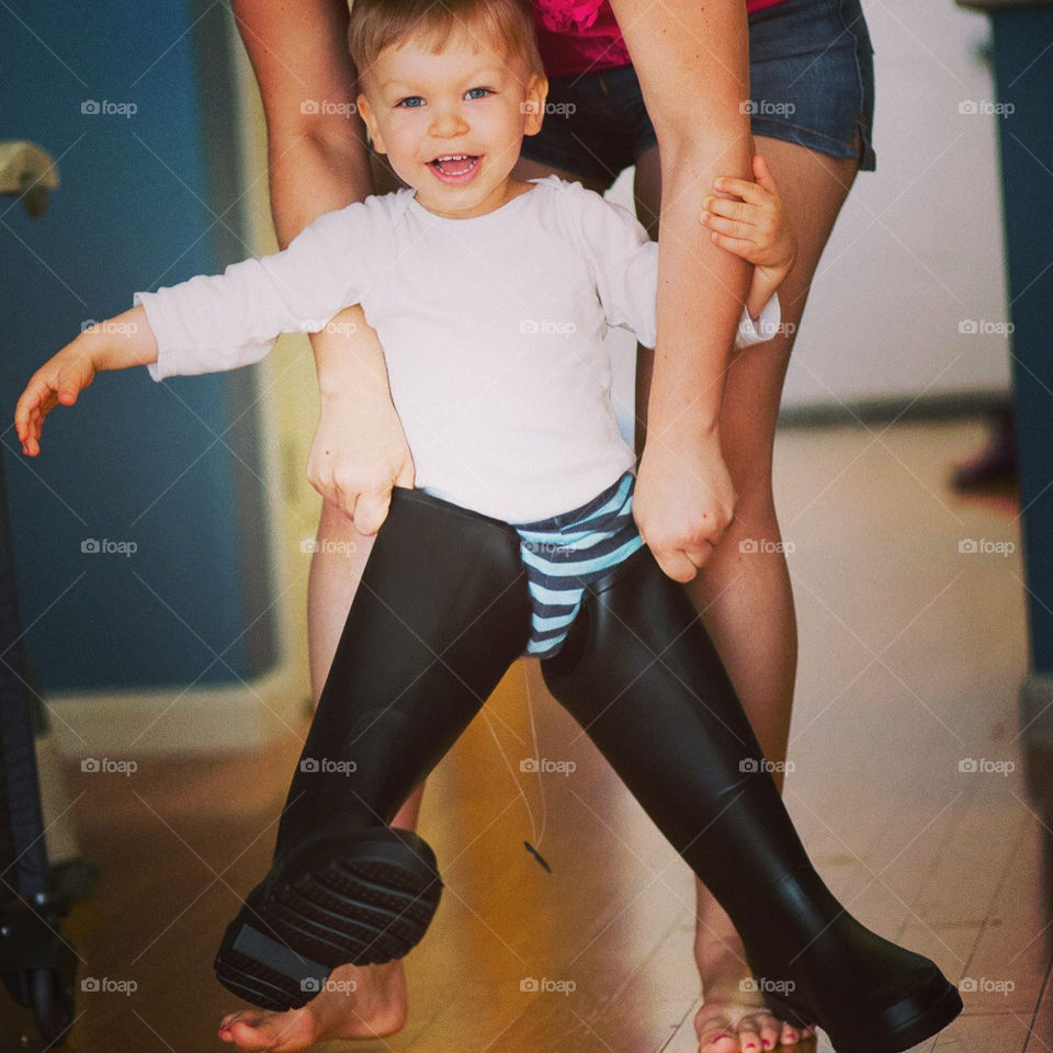 Mom helping son with oversized boots