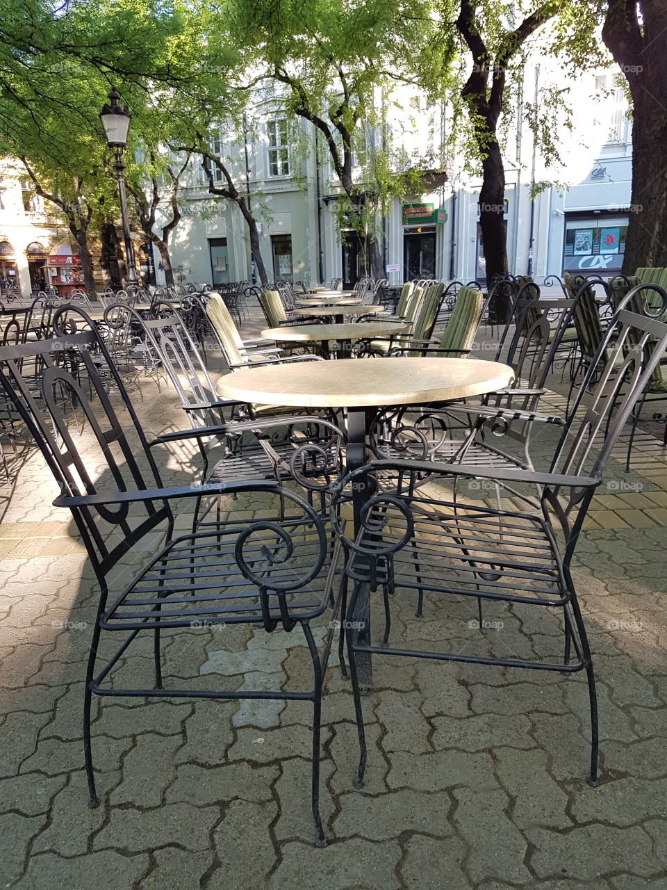restaurant terrace with empty iron tables and chairs