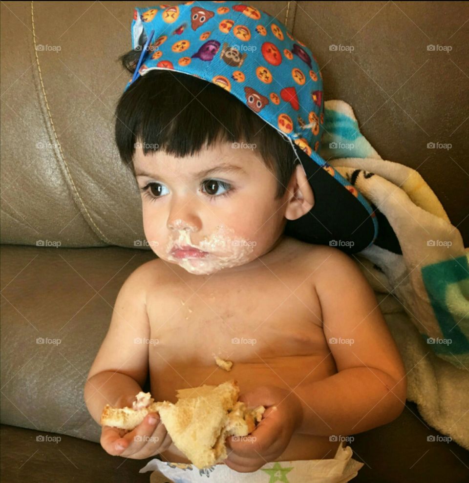 Cute messy baby boy on sofa