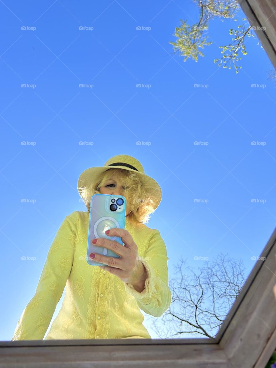 Woman taking a selfie with blue sky in the background 