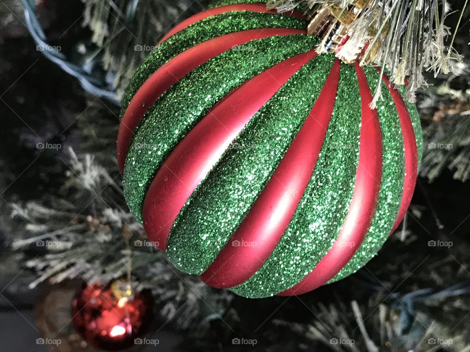 Red and green ornament hanging on a tree