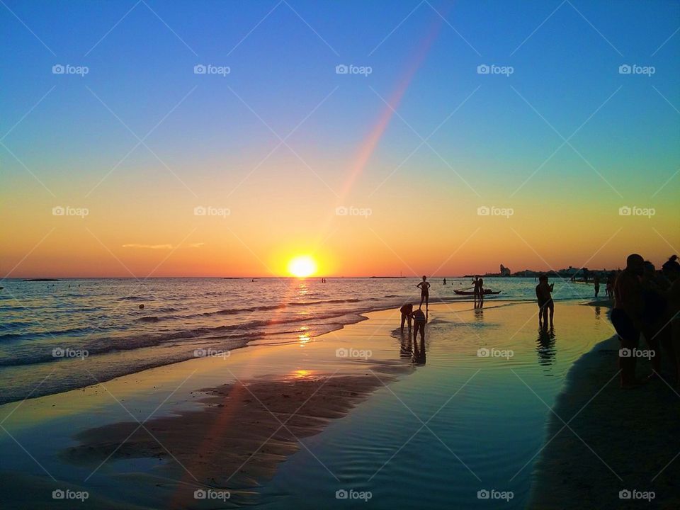 Tourist enjoying on beach during sunset