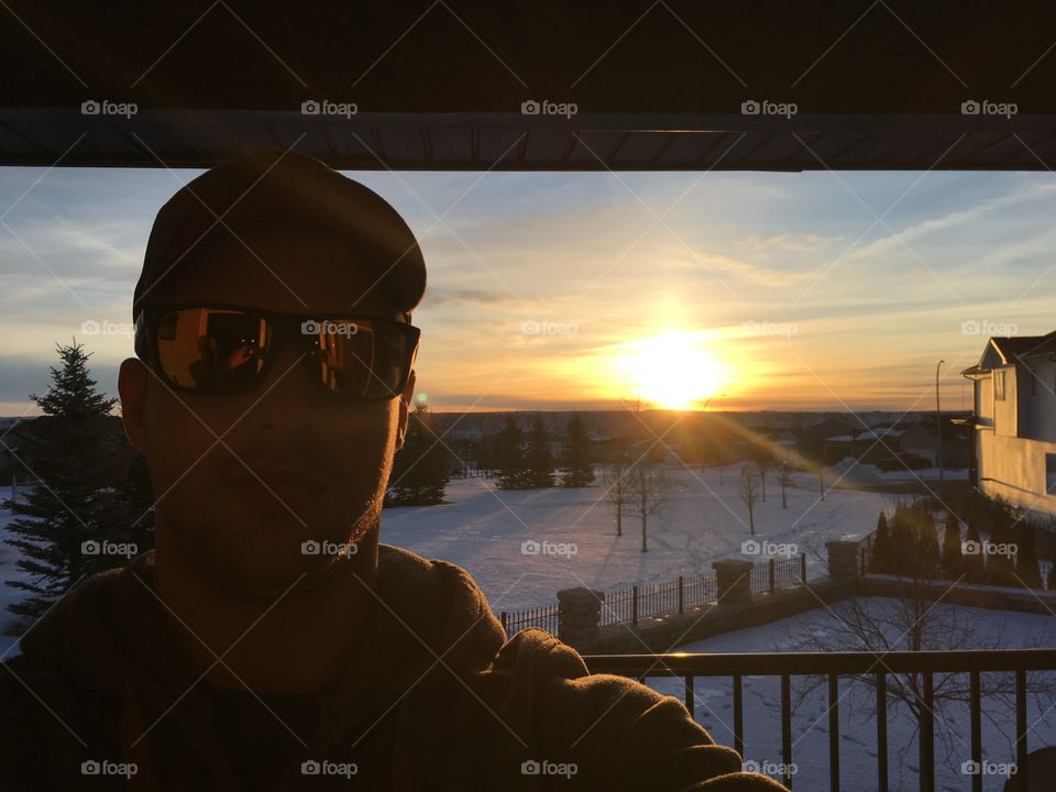 Close-up of a man wearing sunglasses during sunset
