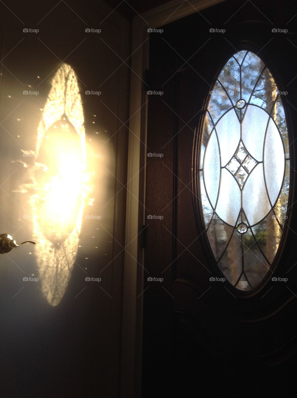Reflection of sunlight through glass door to closet door.