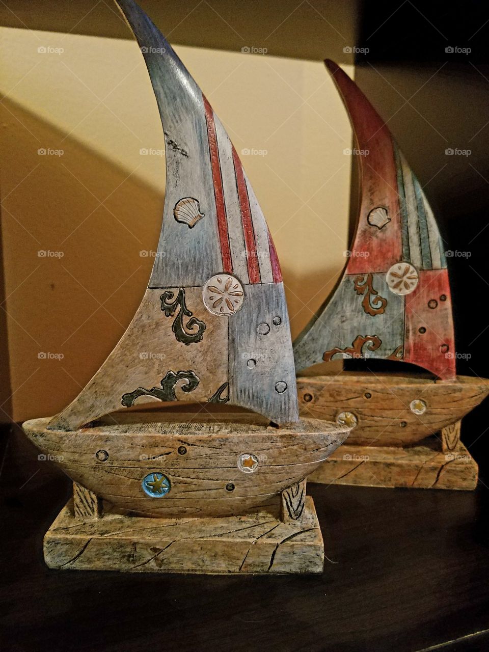 wood carved sailboats with varied colorful designs