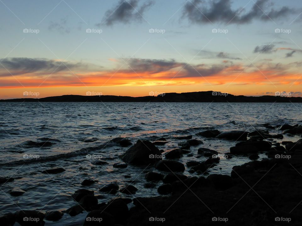 Silhouette of stones at beach during sunset