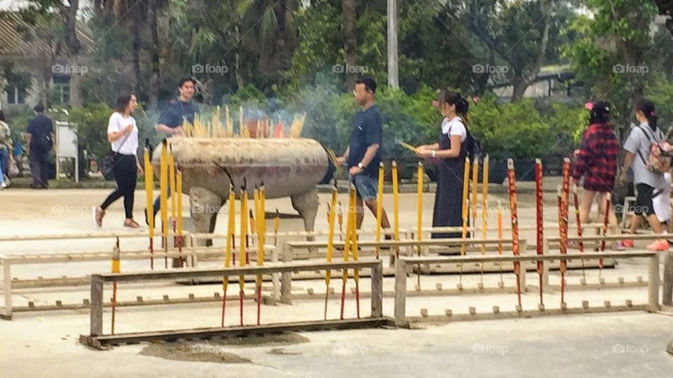 Buddhist Culture Praying to Buddha, by lighting incense, and letting their smokey prayers float to Buddha. Ancient Pottery-Ngong Ping Village, Po Lin Monastery, Lantau Island, Hong Kong. 