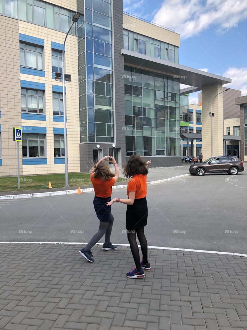 Two teenagers students are playing near the school 