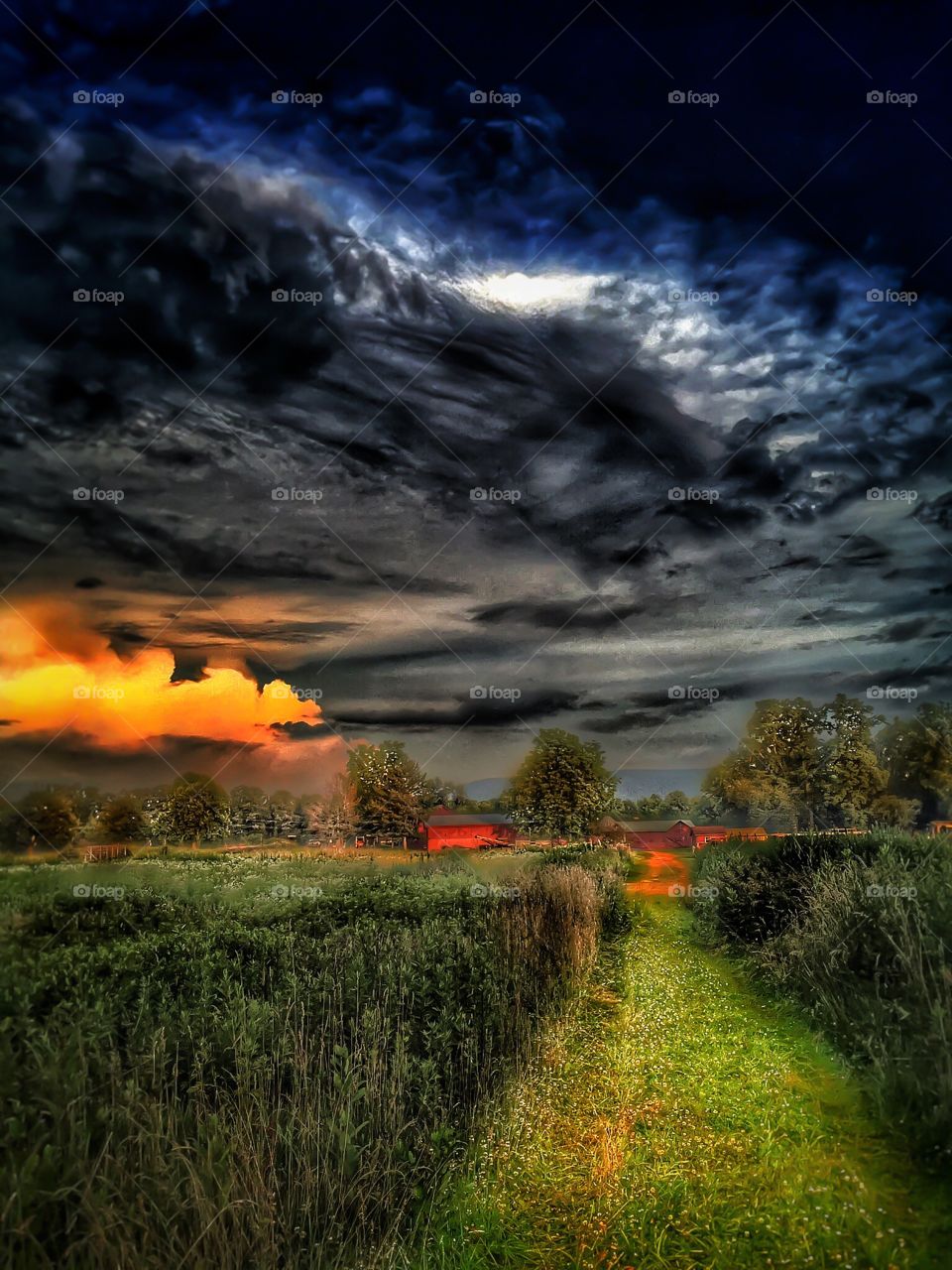 Fire in the sky . It's a storm moving over the farm during sundown 
