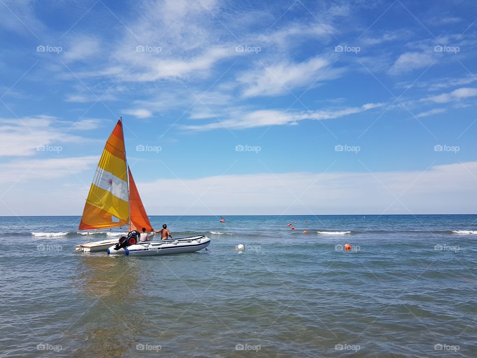 Sailboat and speedboat in the sea