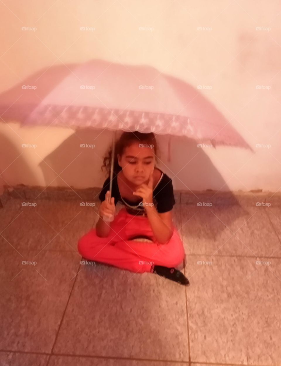 Editors'Choice Photo of the week Criança sentada com pose de dançarina trajando uma camiseta preta listrada e uma calça legging laranja