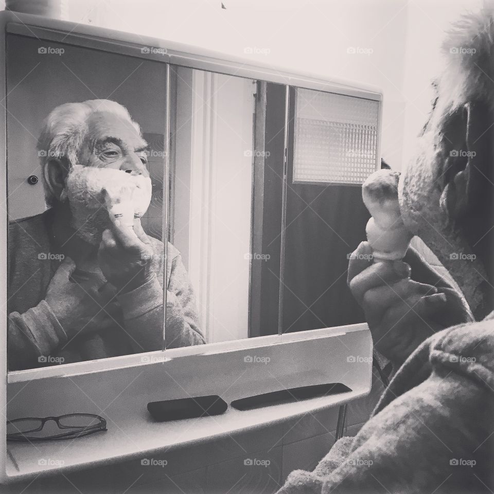 Man applying shaving cream on face