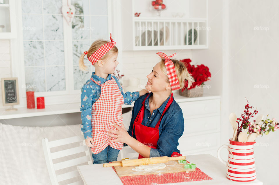 Mom and daughter in the kitchen prepare cookies