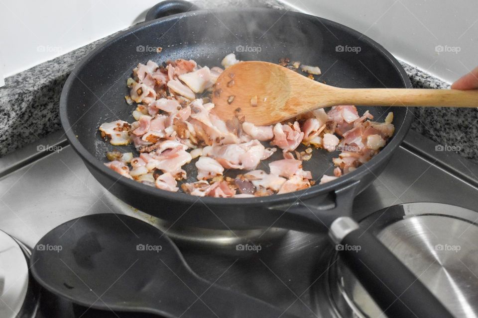 Homecooking cooking Frittata at home and adding and mixing ingredients and removing the Frittata from the pan for cutting and serving on a white plate with tomatoes. Healthy home cooking in kitchen. Breakfast and lunch food preparation.