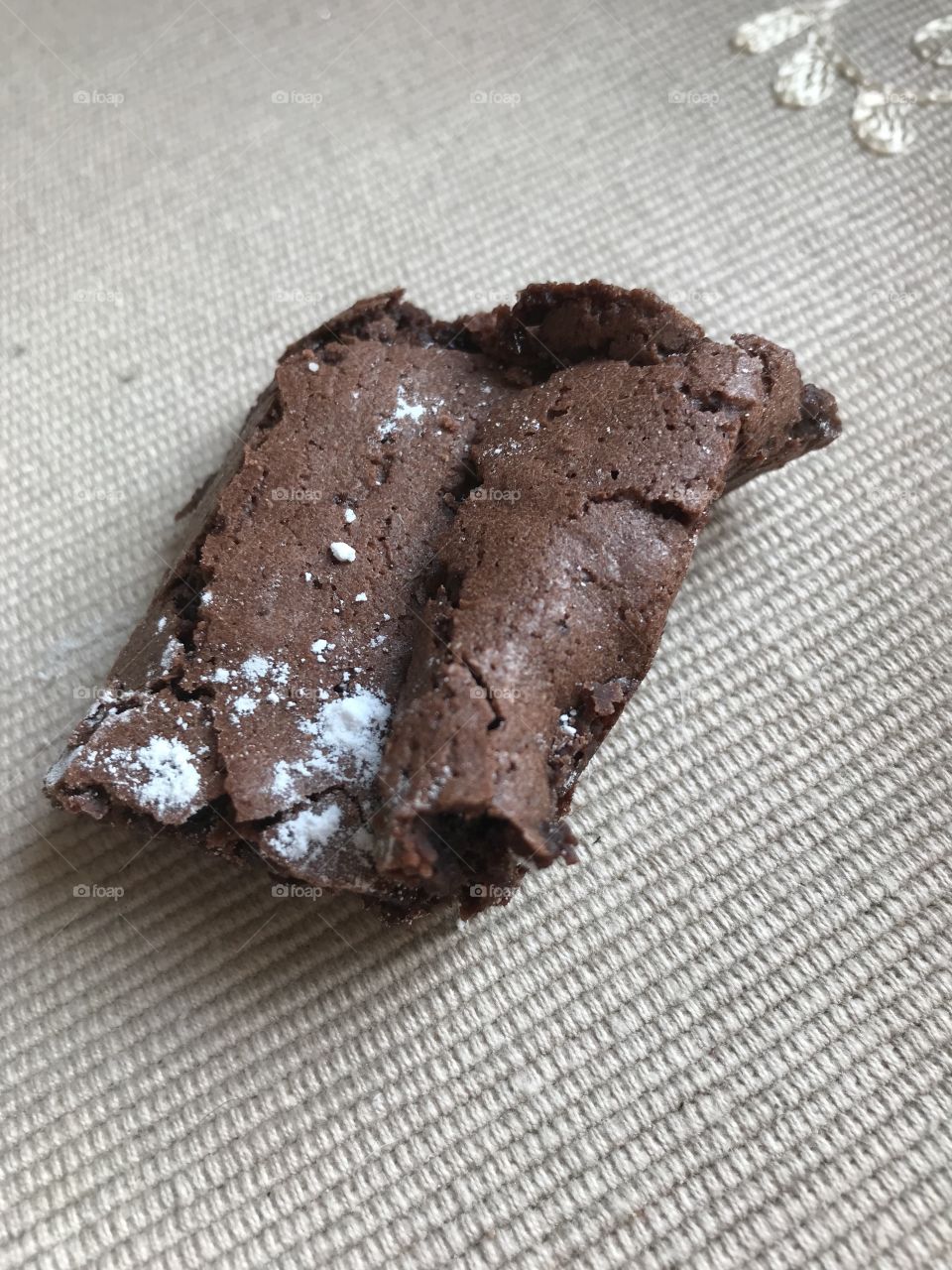 A good brownie piece with icing sugar on top.                                    