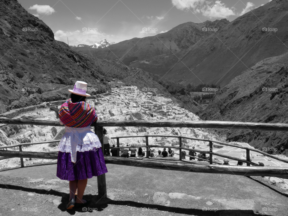 Bolivian woman in colorful local clothes looking over her family's white salt mines