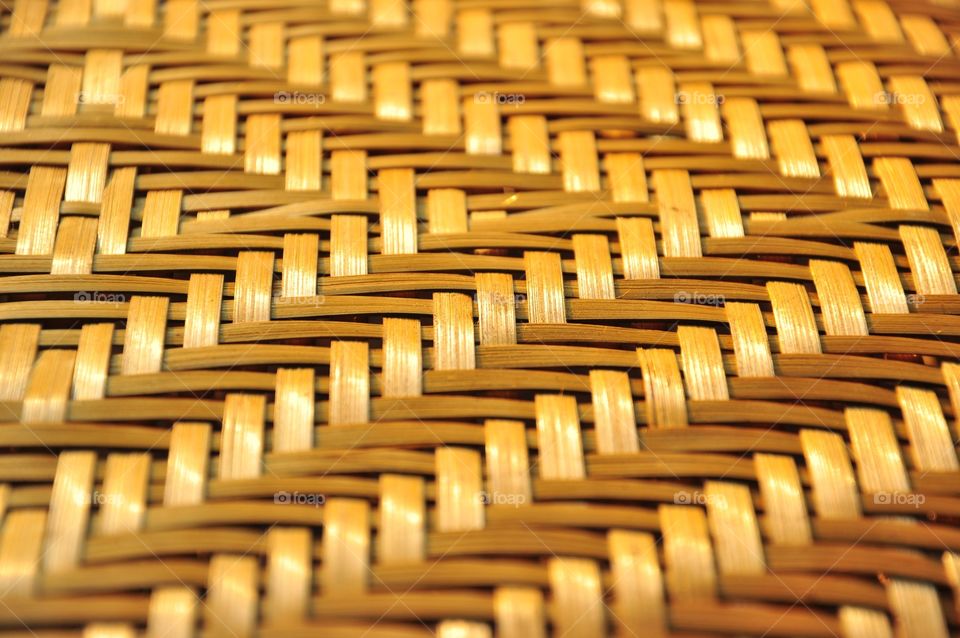 Brown woven bamboo closeup texture. Wicker texture. Winnowing or threshing basket. Woven bamboo pattern. Arrow pattern texture. Abstract texture.