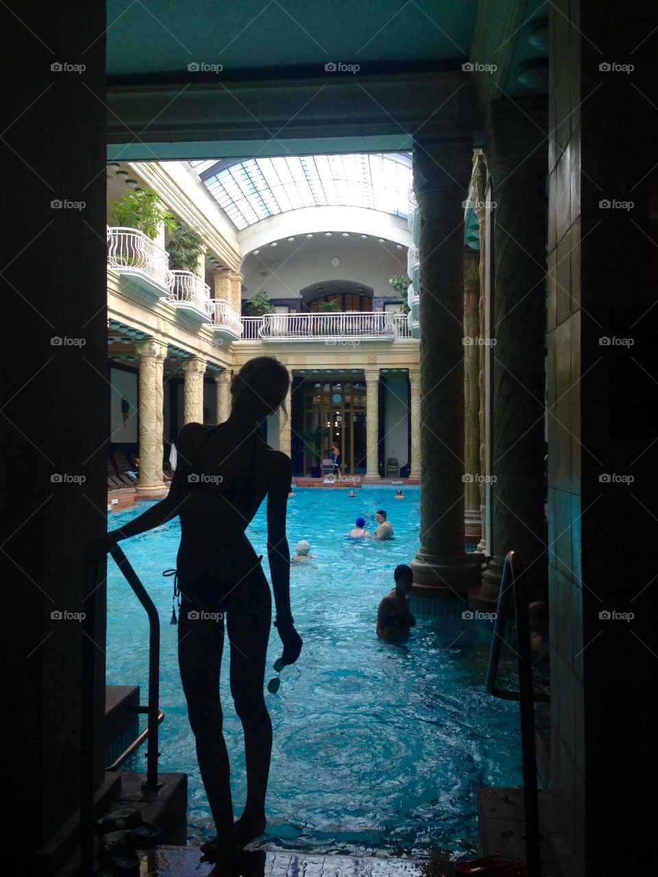 Silhouette of woman standing near the swimming pool