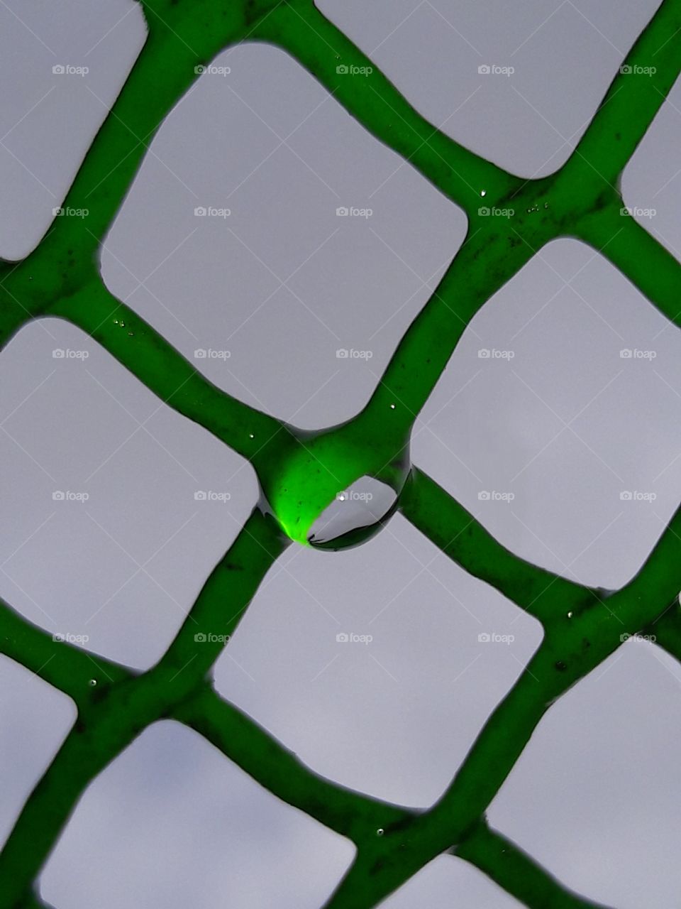 water drop on green grills mesh
