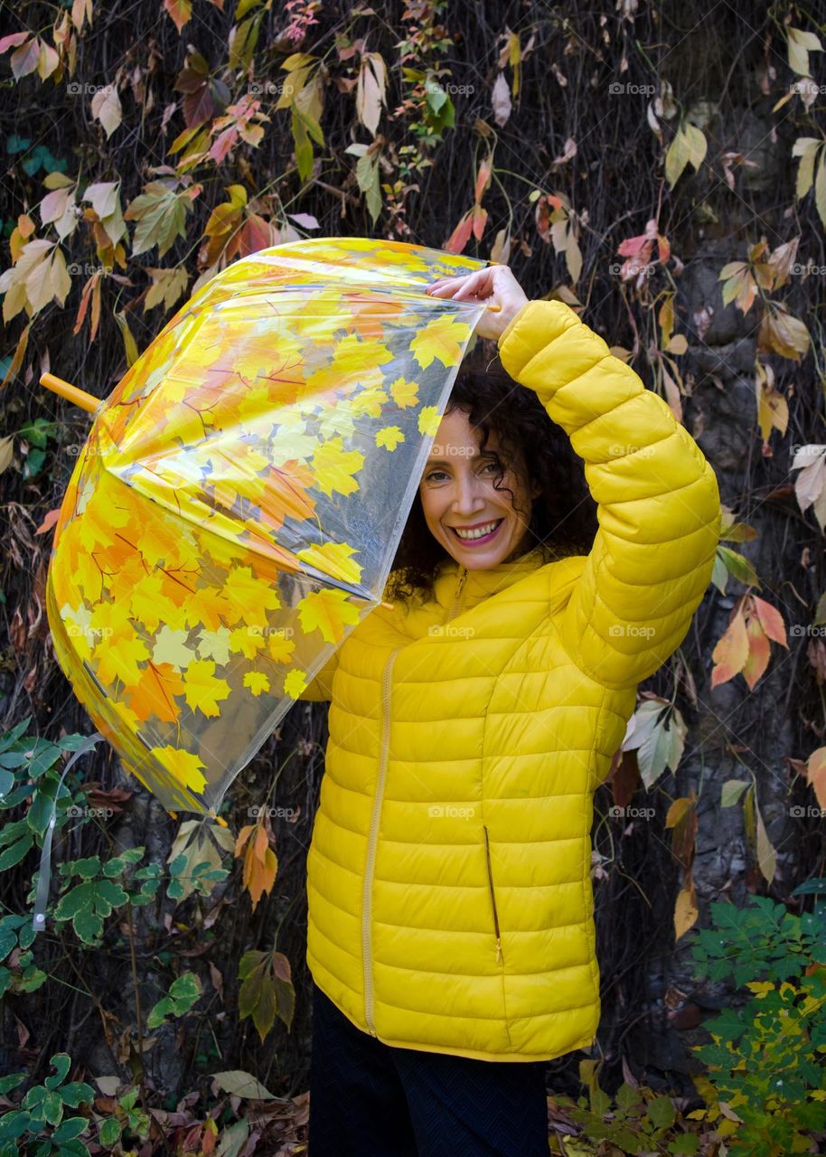 Smiling Woman with Umbrella on Autumn Background