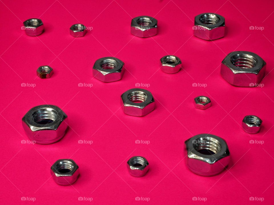 Fixing nuts on pink background