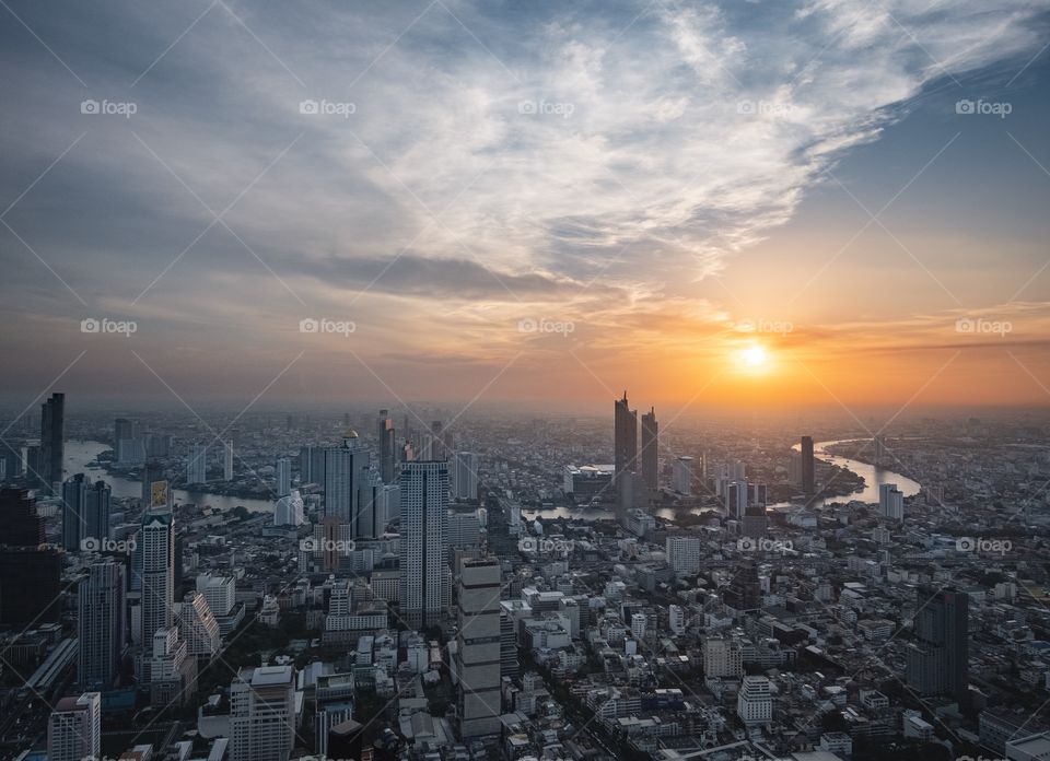 Beautiful light of Sunset shade over the Chao Phraya River and Building in the big city , take photo from MahaNakhon tower , Bangkok Thailand 