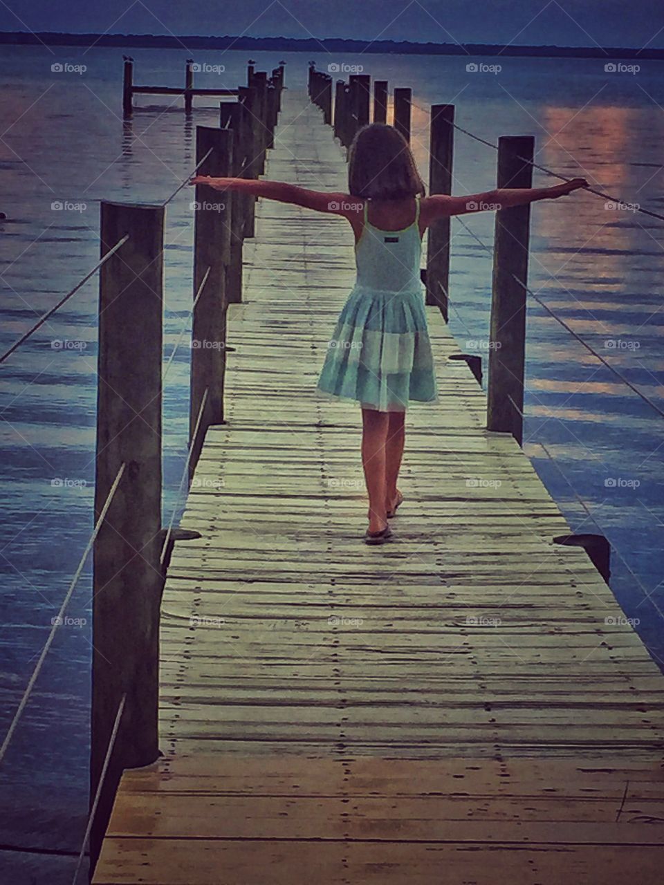 Rear view of a girl walking on pier