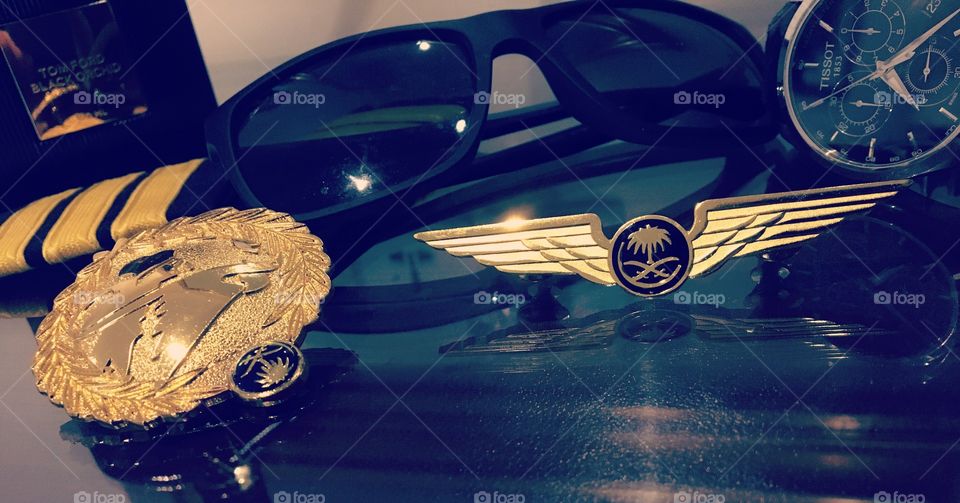 Saudi airlines pilot’s wing and stripes, with a Tissot watch and emporio armani sunglasses
