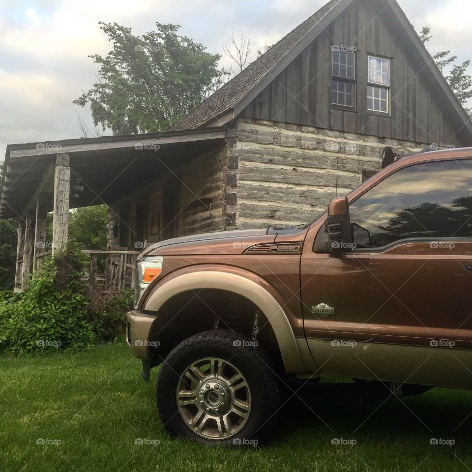 Ford next to log cabin
