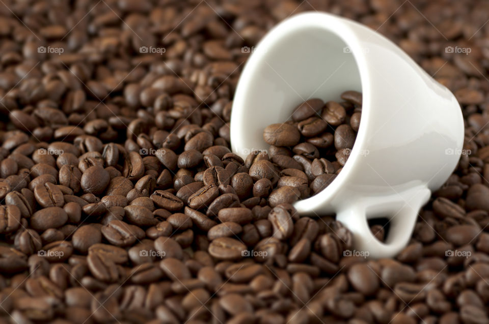 Coffee beans spilled out of coffee cup