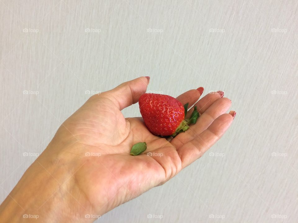 Strawberry on woman palm of hand