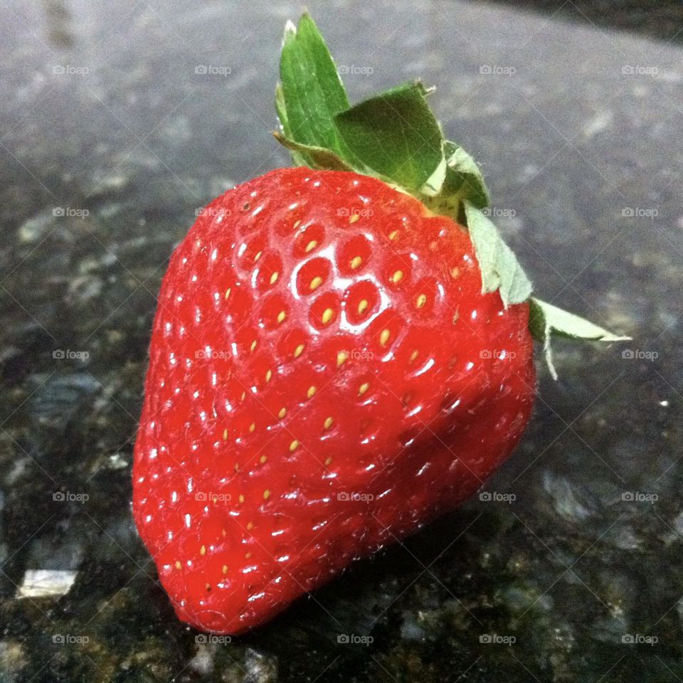 Beautiful fresh red strawberry on the top of a black counter