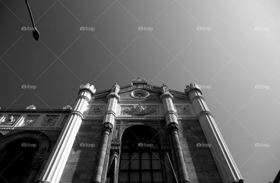 Black and white low angle view shot of building in city against sky.