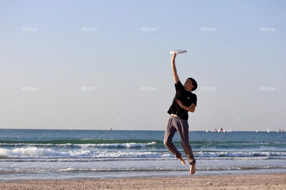 Frisbee stunts on the beach 