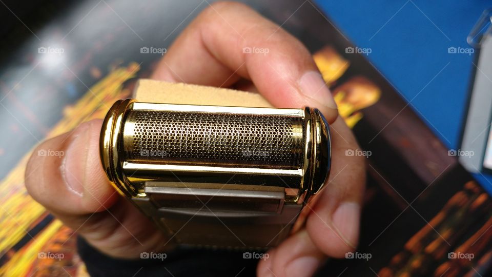 Mão com acessório masculino. Barbeador elétrico.