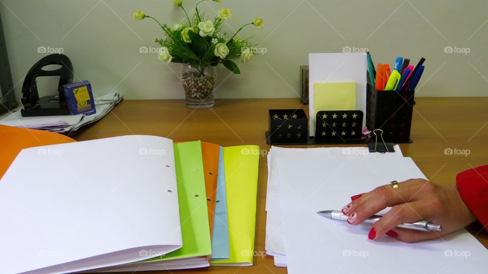 working on the writing table , there is pen , book, pencil , stapler , clip, read , papers, a lot of work ...