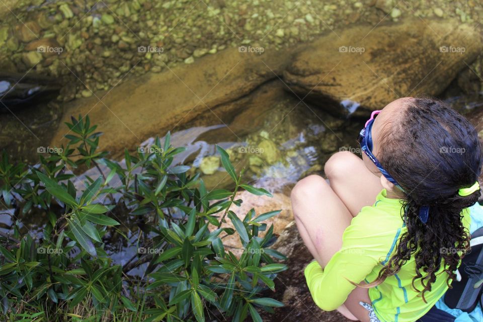 Summer - Little girl refreshing herself in the stream of water in the midst of nature.