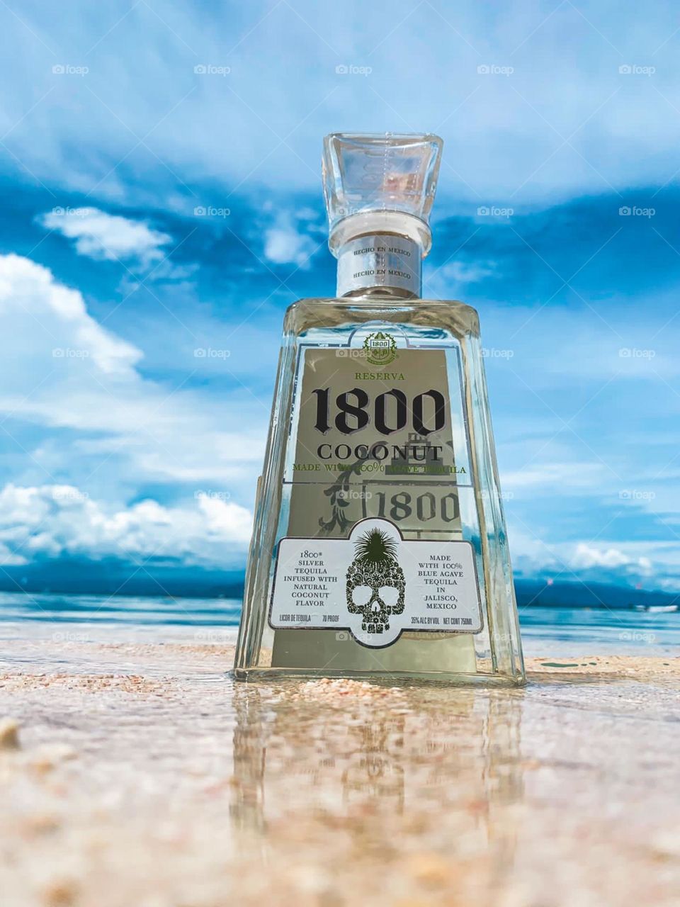 A photo product of alcoholic drink in one of beaches in Bali. This photo shows the beauty nature of Indonesia represented by the beach amd the blue sky.